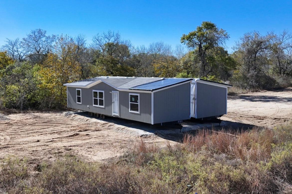 Aerial view of a 28x80 double-wide mobile home being relocated from Texarkana, AR to Arkadelphia, AR by Trailer House Movers, including foundation setup and permit handling.